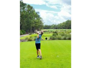 利哈伊埃克斯Holiday home with 1 bedroom的女子在高尔夫球场挥舞高尔夫球杆