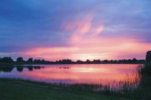 SeehausenSemi-detached houses Hyggelig, Seehausen的湖上日落,湖中有鸭子