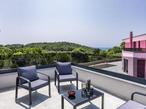 a patio with two chairs and a table on a balcony at Villa in Medulin with swimming pool in Premantura