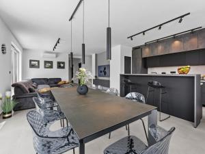a kitchen and living room with a table and chairs at Villa in Medulin with swimming pool in Premantura