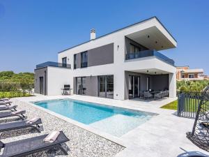 a house with a swimming pool in front of it at Villa in Medulin with swimming pool in Premantura