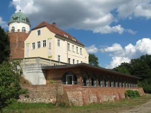ein Gebäude mit einem Turm auf einer Ziegelmauer in der Unterkunft Villa Romantica Lenzen in Körbitz