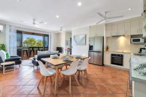 una cucina e un soggiorno con tavolo e sedie di Ocean Vista Nightcliff Foreshore Apartment a Nightcliff