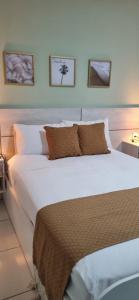 Un pat sau paturi într-o cameră la Residencial New Stilo-Falésia +16 fotografii