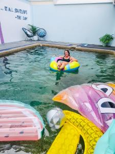 凯恩斯The Espy Hostel的坐在游泳池内胎上的女人