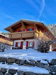 a log cabin with a balcony in the snow at Ferienhaus Gollbichl in Sachrang