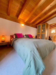 a large bed in a bedroom with a wooden ceiling at Ferienhaus Gollbichl in Sachrang