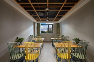 北京秋果s酒店的用餐室配有木桌和黄色椅子