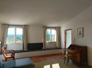 a living room with a bench in front of two windows at La Procureuse in Barjols