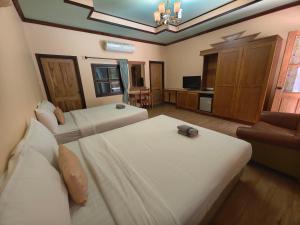 Ban Tha Maprangเขาใหญ่ฮาร์ทแลนด์ khaoyai heartland的一间酒店房间，配有两张床和一张沙发