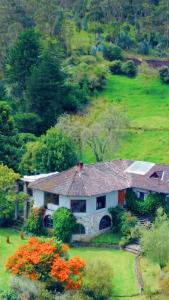 a house in the middle of a field with flowers at Nalanda Boutique Mountain Hotel in Patate