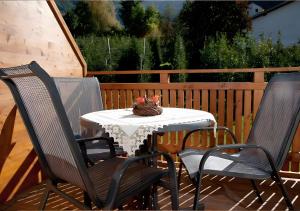 Una mesa con dos sillas y un jarrón de flores encima. en Reiterhof Siglgut, en Tarres