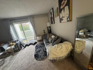 a living room with a couch and a mirror at Comfort zone in Indianapolis