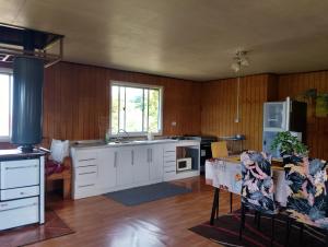 a kitchen with white cabinets and a table in a room at Agroturismo Silvestre Marly in San José