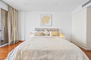 迪拜Burj View Luxury 1BR - Full Sea View Private Beach - Anantara Palm的白色卧室配有一张带两盏灯的大床 更多30张照片