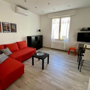 a living room with a red couch and a table at La vista Azzurra in Bordighera