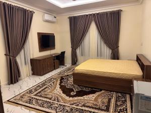 a bedroom with a bed and a flat screen tv at KumKum Apartments in Pakoto