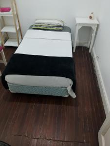 a bed sitting on a wooden floor in a room at Mi casa in Rosario