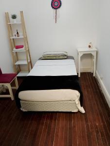 a bed in a room with a wooden floor at Mi casa in Rosario