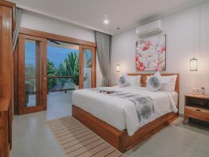 a bedroom with a large bed and a window at Villa Royal in Singaraja +67 photos