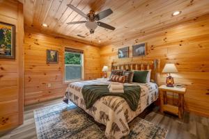 a log cabin bedroom with a bed and a ceiling fan at Hibearnator in Sevierville