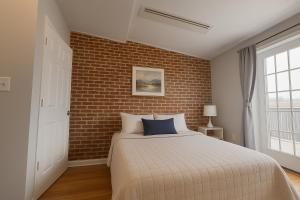 a bedroom with a bed and a brick wall at Downtown 1BD APT, Walk to Stadiums, Free Parking in Baltimore