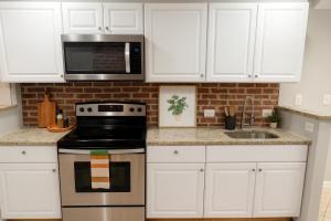 a kitchen with white cabinets and a stove and microwave at Downtown 1BD APT, Walk to Stadiums, Free Parking in Baltimore