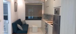 a small kitchen with a blue couch in a room at غزو 15 in Aydūn