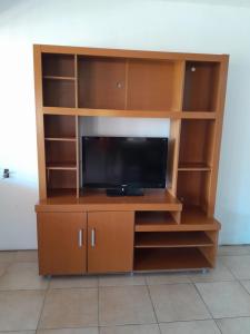 een entertainmentcentrum met een flatscreen-tv bij La Morada de tus Sueños VCP con vista al LAGO in Villa Carlos Paz