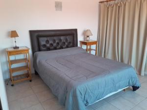 een slaapkamer met een bed en twee nachtkastjes met lampen bij La Morada de tus Sueños VCP con vista al LAGO in Villa Carlos Paz +25 foto's