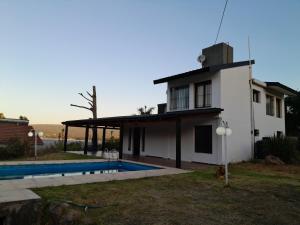 een huis met een zwembad ervoor bij La Morada de tus Sueños VCP con vista al LAGO in Villa Carlos Paz