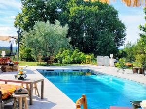 a pool in a backyard with a table and chairs at La Procureuse in Barjols