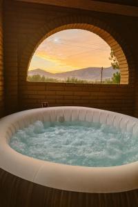 Francisco ZarcoHotel Flamora的带窗户的按摩浴缸，可以欣赏日落美景