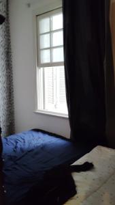 a bedroom with a bed and a window at Quarto compartilhado para Homens in Sao Paulo