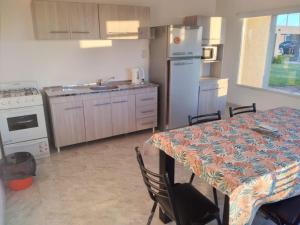 een keuken met een tafel en een keuken met een koelkast bij Mi Descanso in Balneario Claromecó +11 foto's
