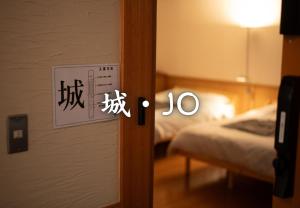 une porte vers une pièce avec un lit et un panneau dans l'établissement 鈴籠城 城の間 ダブルベッド2台 二段ベッド1台, à Nagahama 6 autres photos