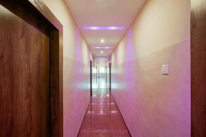 einen Korridor mit lila Lichtern im Flur in der Unterkunft Hotel O Blue Sagar in Puri