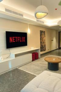 een woonkamer met een Netflix-tv aan de muur bij Luxury 1BR with Nile View at Hilton Hotel in Caïro