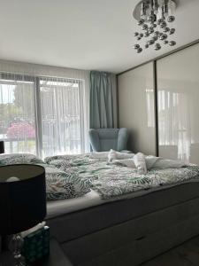 a bedroom with a bed and a chair and a window at Villa Kulacs in Veľký Meder