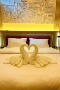 twee zwanen vormen een hart op een bed bij Luxury 1BR with Nile View at Hilton Hotel in Caïro