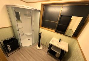 ein kleines Badezimmer mit Dusche und Waschbecken in der Unterkunft 鈴籠城 全室貸切 各部屋ダブルベッド2台 in Nagahama