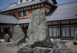 ein großer Felsen vor einem Gebäude in der Unterkunft 鈴籠城 全室貸切 各部屋ダブルベッド2台 in Nagahama
