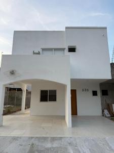 ein weißes Gebäude mit einem Torbogen im Hof in der Unterkunft La casa blanca in Mezcales