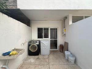 a laundry room with a washing machine and a window at La casa blanca in Mezcales