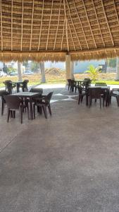 eine Gruppe von Tischen und Stühlen unter einem Strohschirm in der Unterkunft La casa blanca in Mezcales