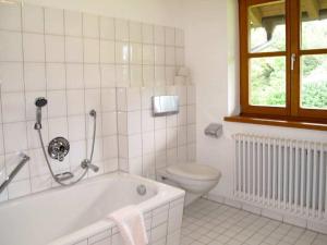 un bagno bianco con vasca e WC di Holiday home with 2 bedrooms a Buchenberg