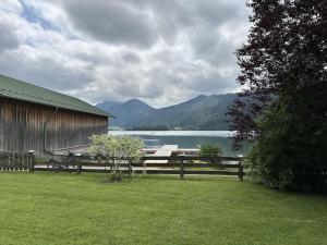 Pine-paneled room by the lake في شليرزيه: سياج خشبي بجوار بحيرة وحظيرة