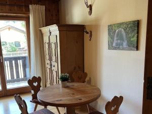 Pine-paneled room by the lake في شليرزيه: طاولة وكراسي خشبية في غرفة بها نافذة