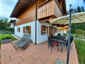 IllachHoliday home in Allgäu with 3 bedrooms的带桌椅和遮阳伞的露台
