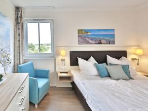 a bedroom with a bed and a blue chair at Dream holiday apartment with pool sauna MB in Börgerende-Rethwisch +34 photos